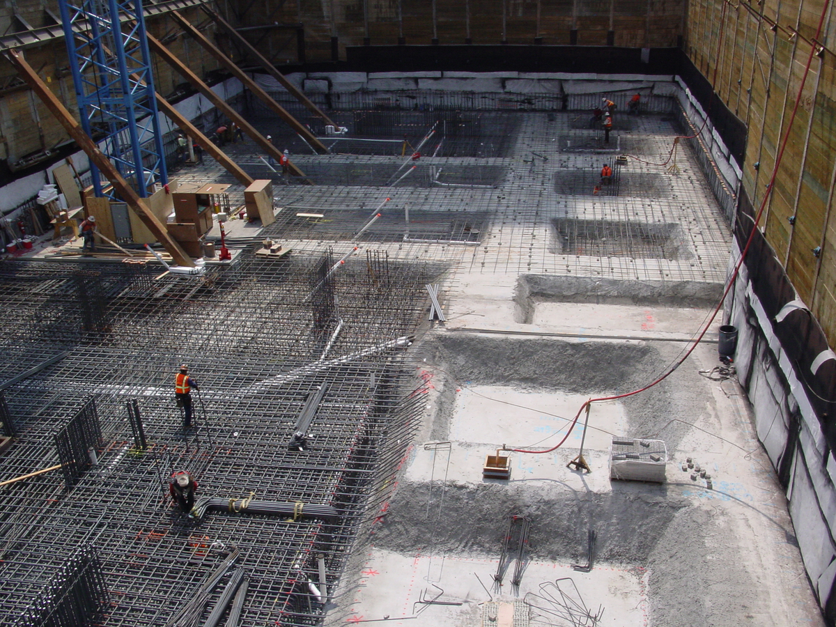 This job site features a waterproofing system installation with a few people wearing bright orange vests.